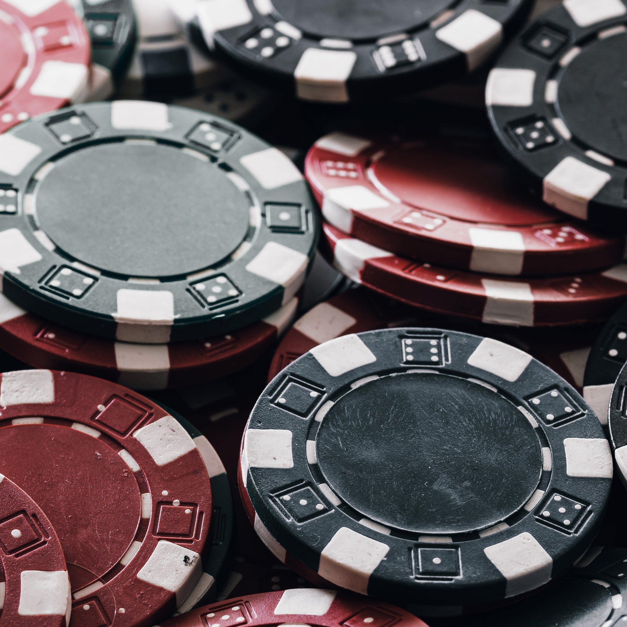 A stacked poker chip set featuring red, black, and green gambling chips, commonly used as casino chips and game chips for home games and poker table setups | MRC Poker